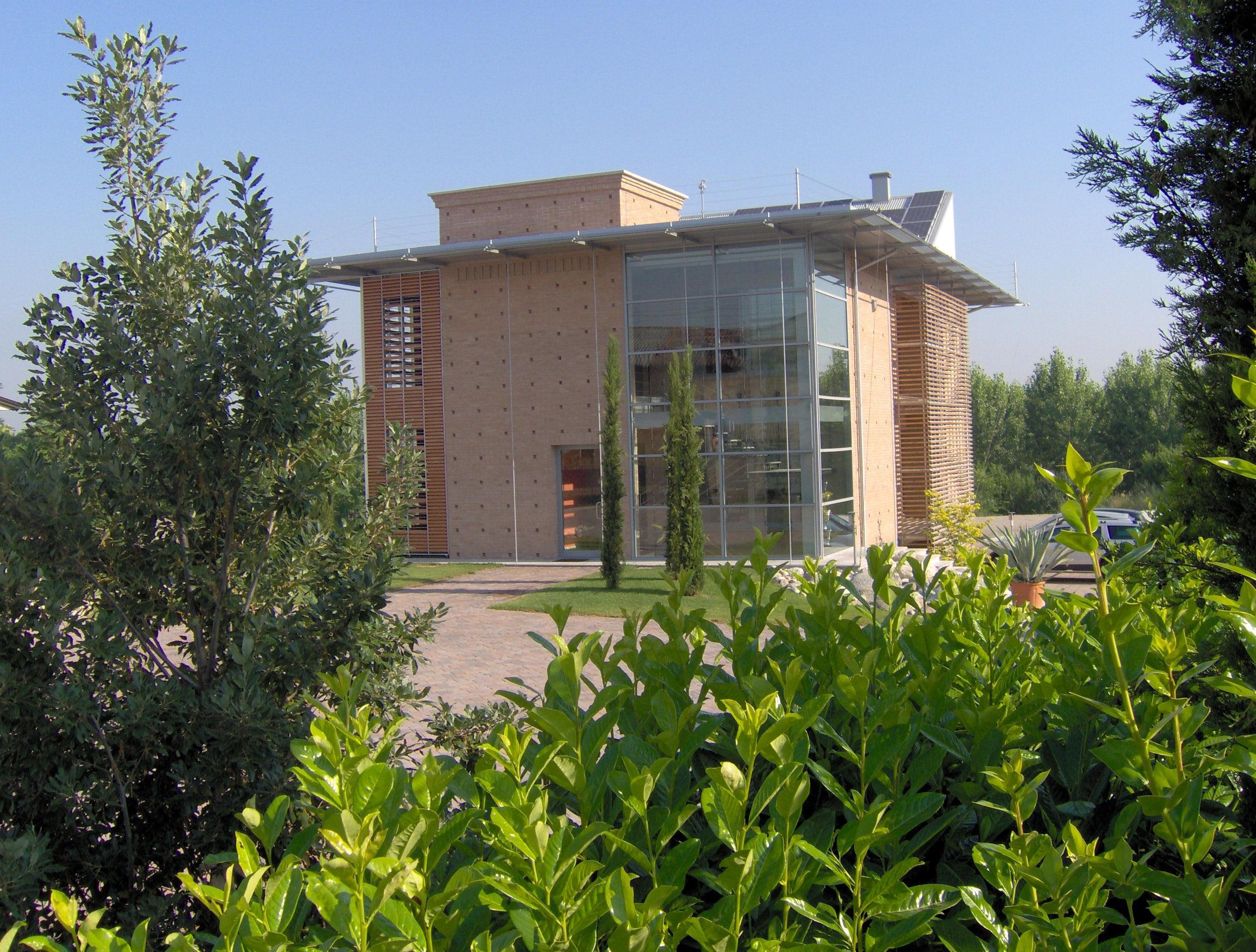 La sede di Bosio Costruzioni a San Bassano vista dal viale d’ingresso, tra cipressi e siepi